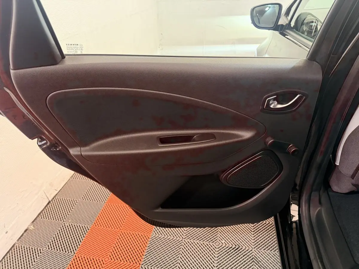 Vue intérieure de la porte arrière gauche noire d'une Renault ZOE 2024 avec poignée et haut-parleur intégrés.