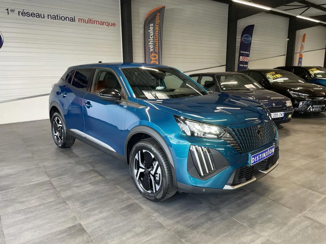 Peugeot 2008 bleu 3/4 avant droit en showroom, avec calandre noire et jantes alliage bi-ton.
