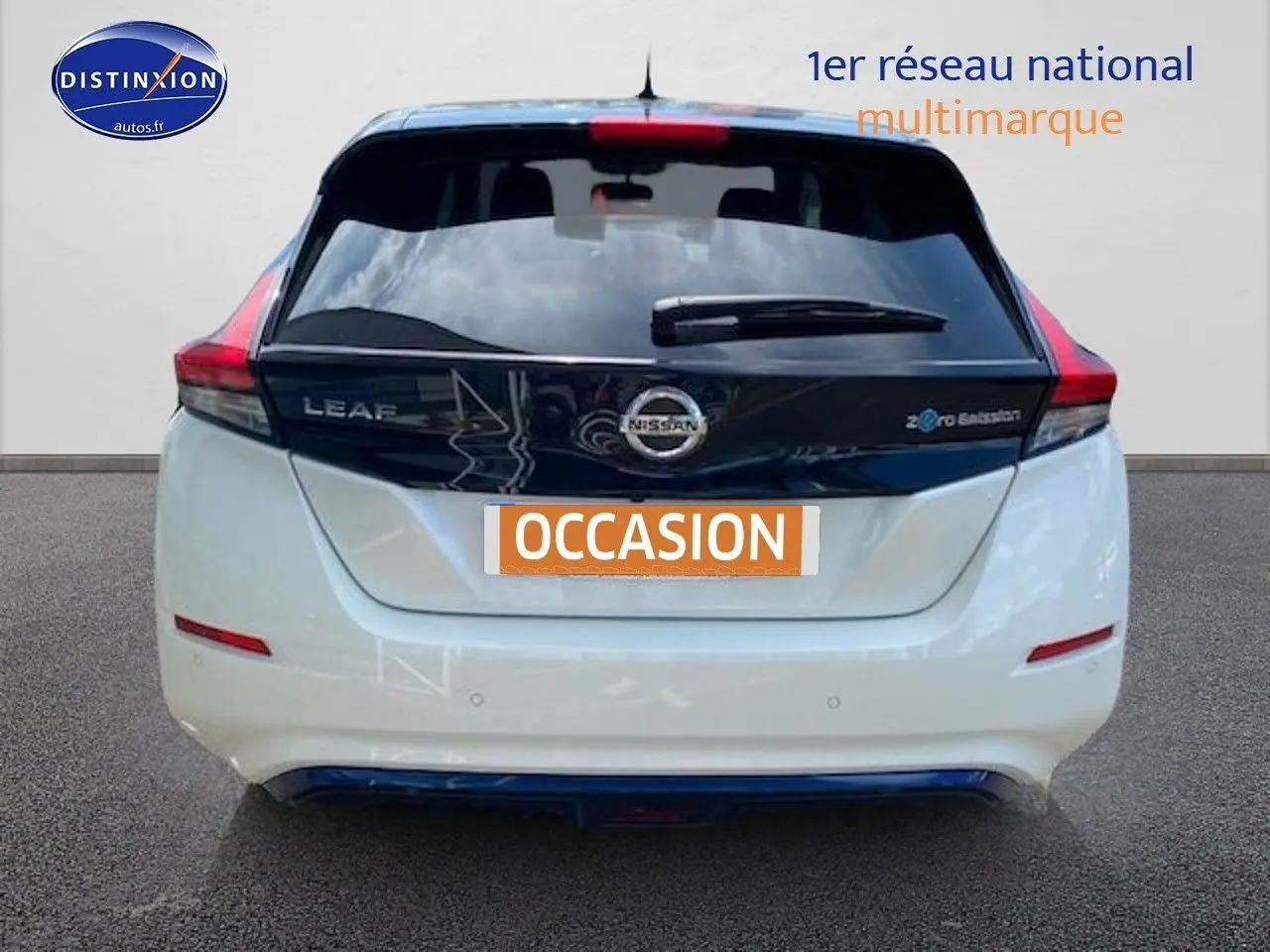 Vue arrière d'une Nissan Leaf électrique 40kWh Acenta blanc nacré métallisé avec logo et feux rouges distinctifs.