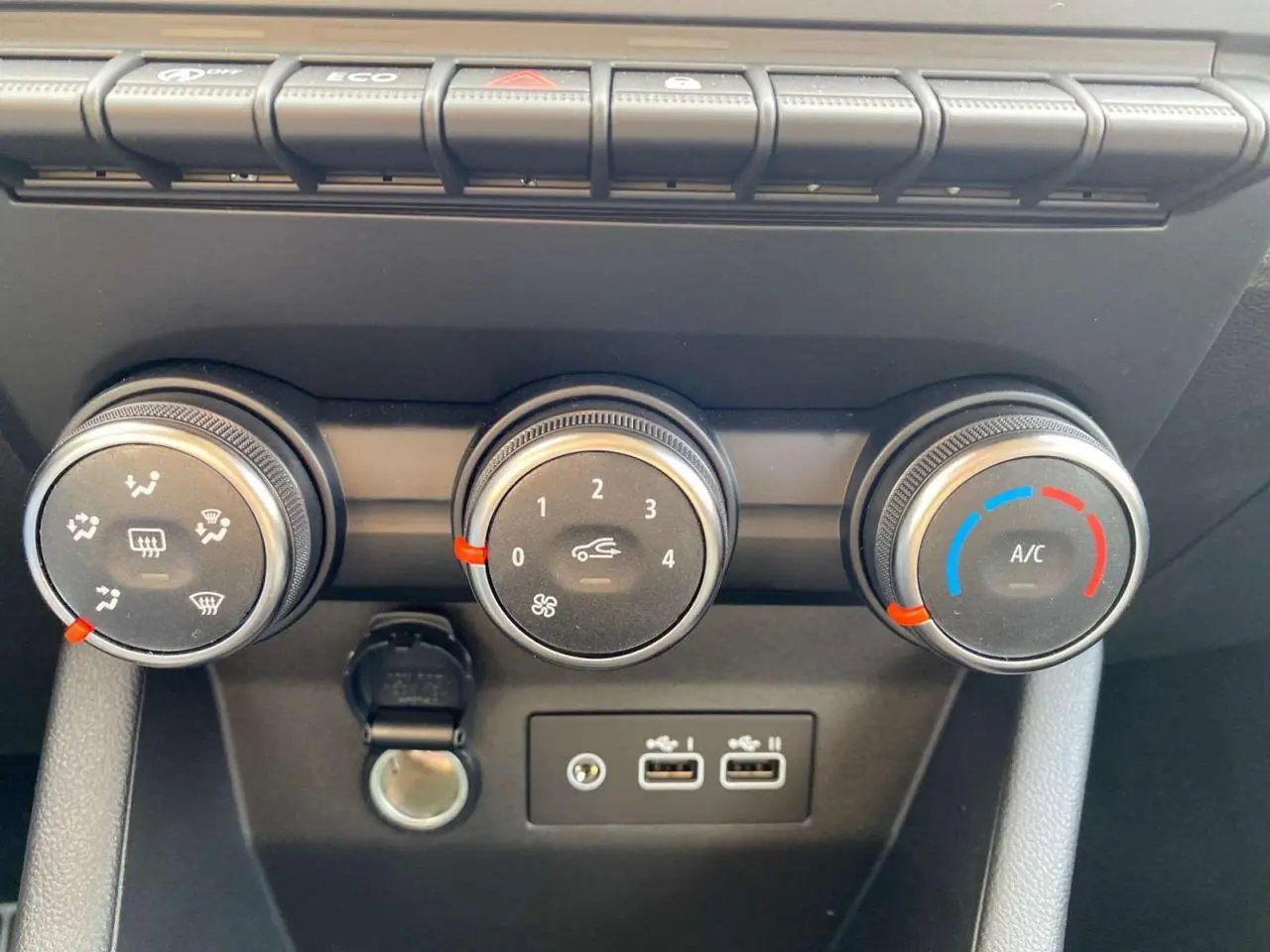 Gros plan sur les commandes de climatisation manuelle et les ports USB de la Renault Clio 1.5 Blue dCi gris schiste.