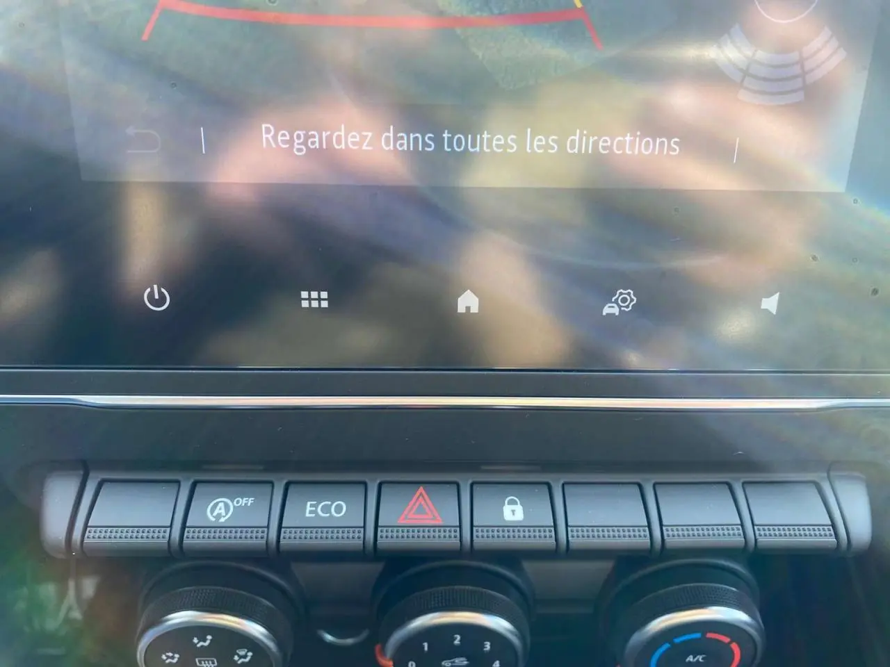 Gros plan sur la console centrale de la Renault Clio 2025 gris schiste, montrant les commandes climatisation et boutons fonctionnels.