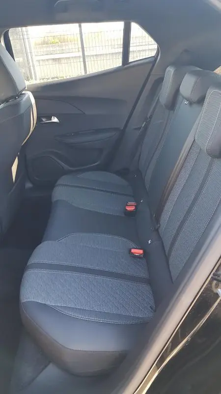 Vue intérieure côté gauche des sièges arrière noirs du Peugeot 2008 Hybrid 145 e-DCS6 Allure 2025, avec ceintures et appuie-têtes.
