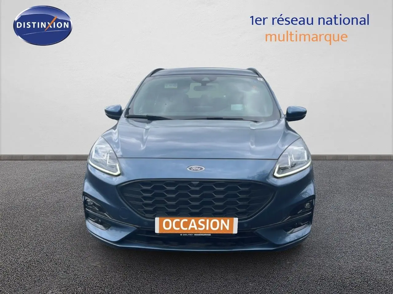 Vue frontale d'un Ford Kuga 2024 bleu chrome métal avec calandre noire et phares LED allumés.