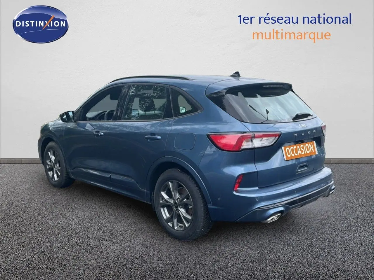Vue 3/4 arrière droite d'un Ford Kuga 2024 bleu chrome métal avec finition ST-LINE et double sortie d'échappement.