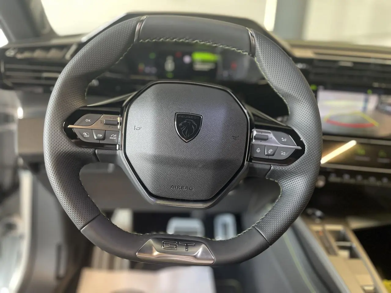Volant cuir noir Peugeot 308 GT 2025 vu de face avec commandes intégrées et logo lion central.