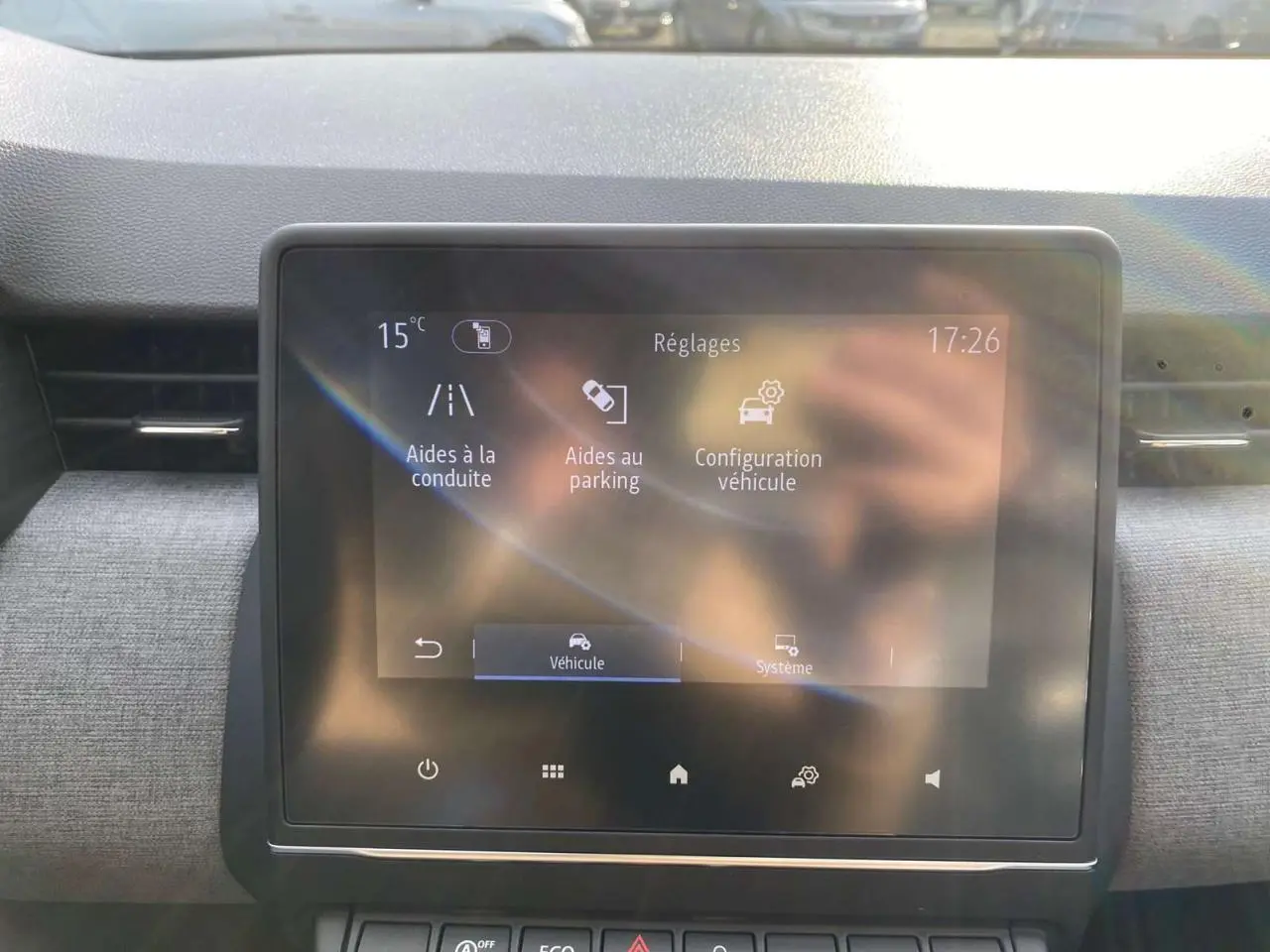 Écran tactile central de la Renault Clio 2025 affichant les réglages d’aides à la conduite et au parking.