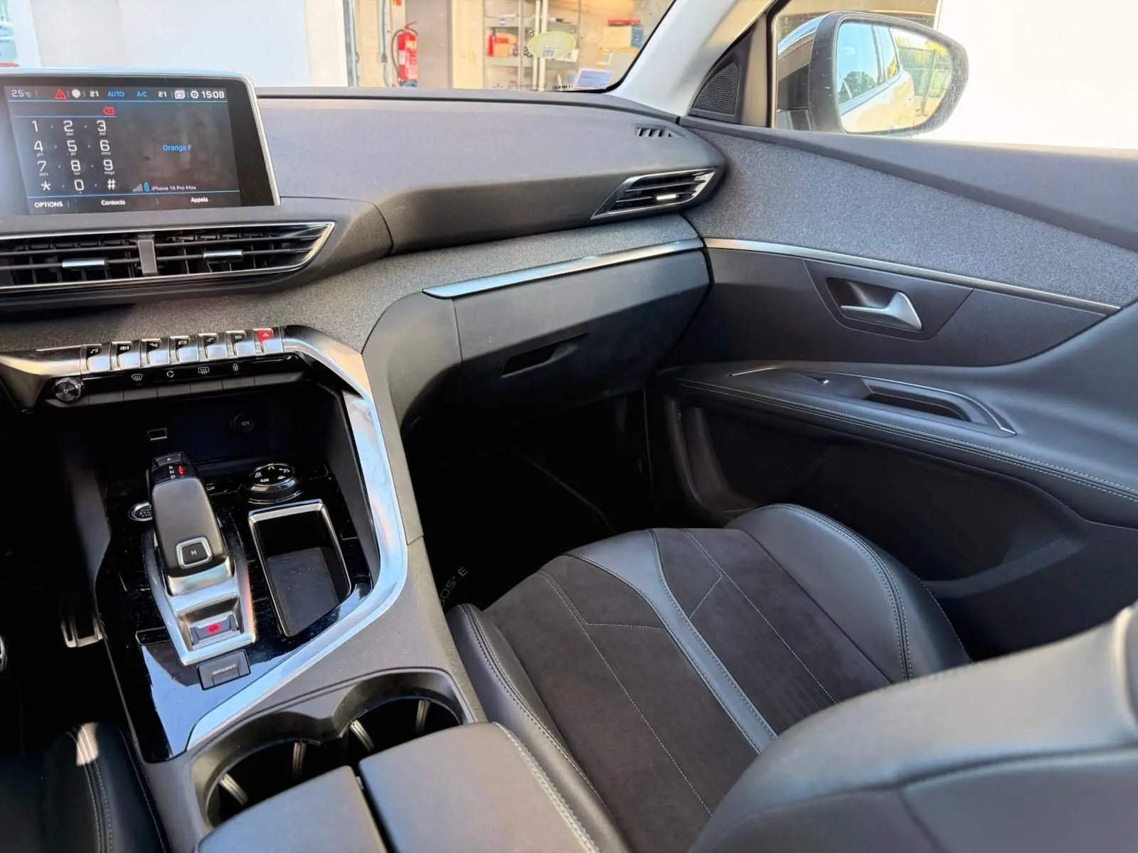 Gros plan sur le bouton d'ouverture du hayon du Peugeot 3008 blanc nacré, intérieur tableau de bord.