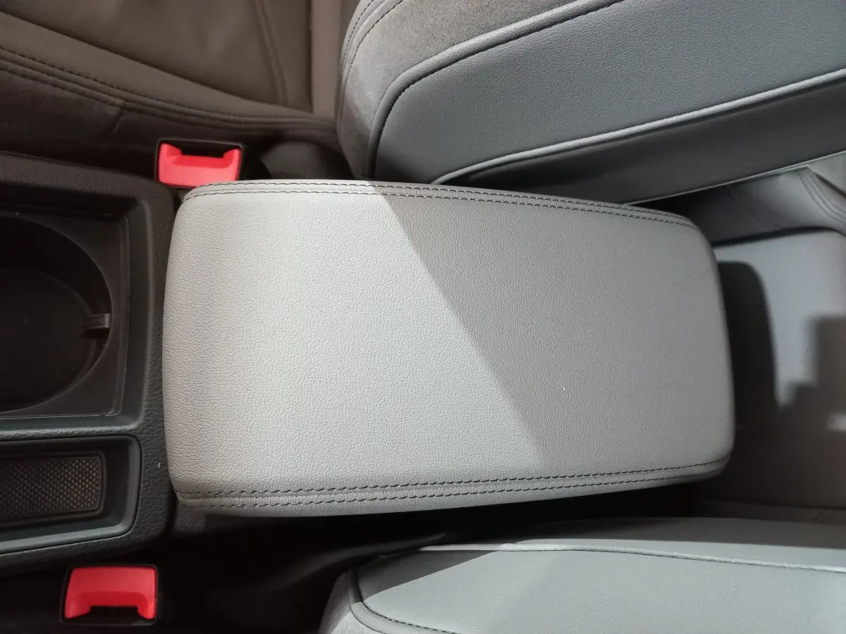 Gros plan sur l'accoudoir central en cuir gris clair de l'Audi Q3 45 TFSI e S line hybride rechargeable.