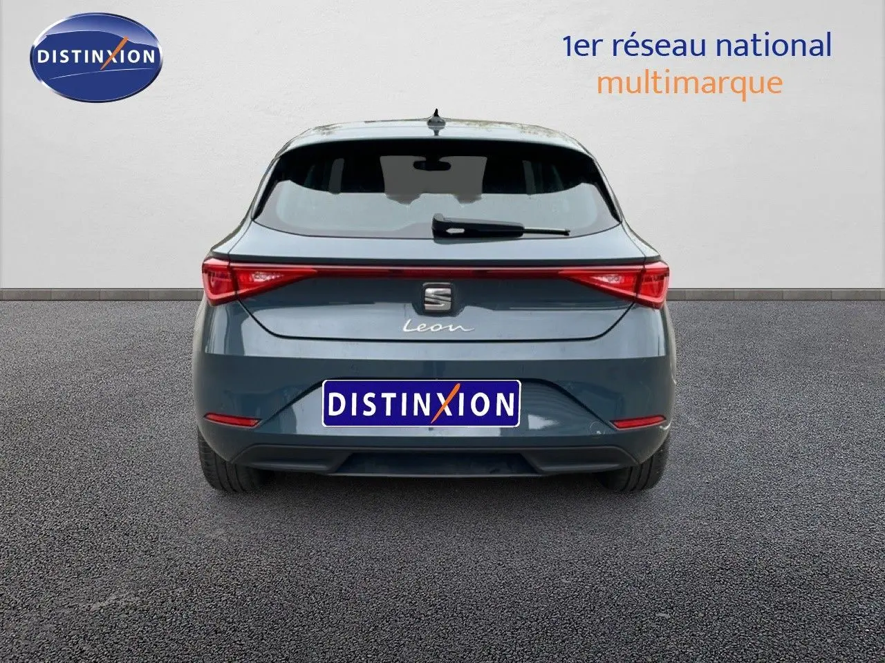Vue arrière d'une SEAT Leon gris magnétique métal 2025 avec feux arrière connectés et logo central.