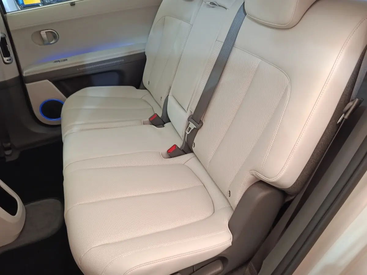 Vue latérale des sièges arrière beige clair en cuir perforé de la Hyundai IONIQ BEV 77KWH AWD Executive 2023.