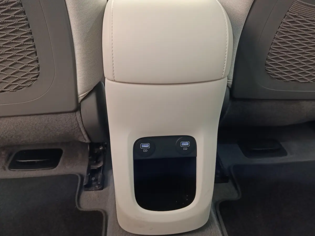 Vue rapprochée de la console arrière beige du Hyundai IONIQ 2023 avec deux ports USB visibles entre les sièges avant.