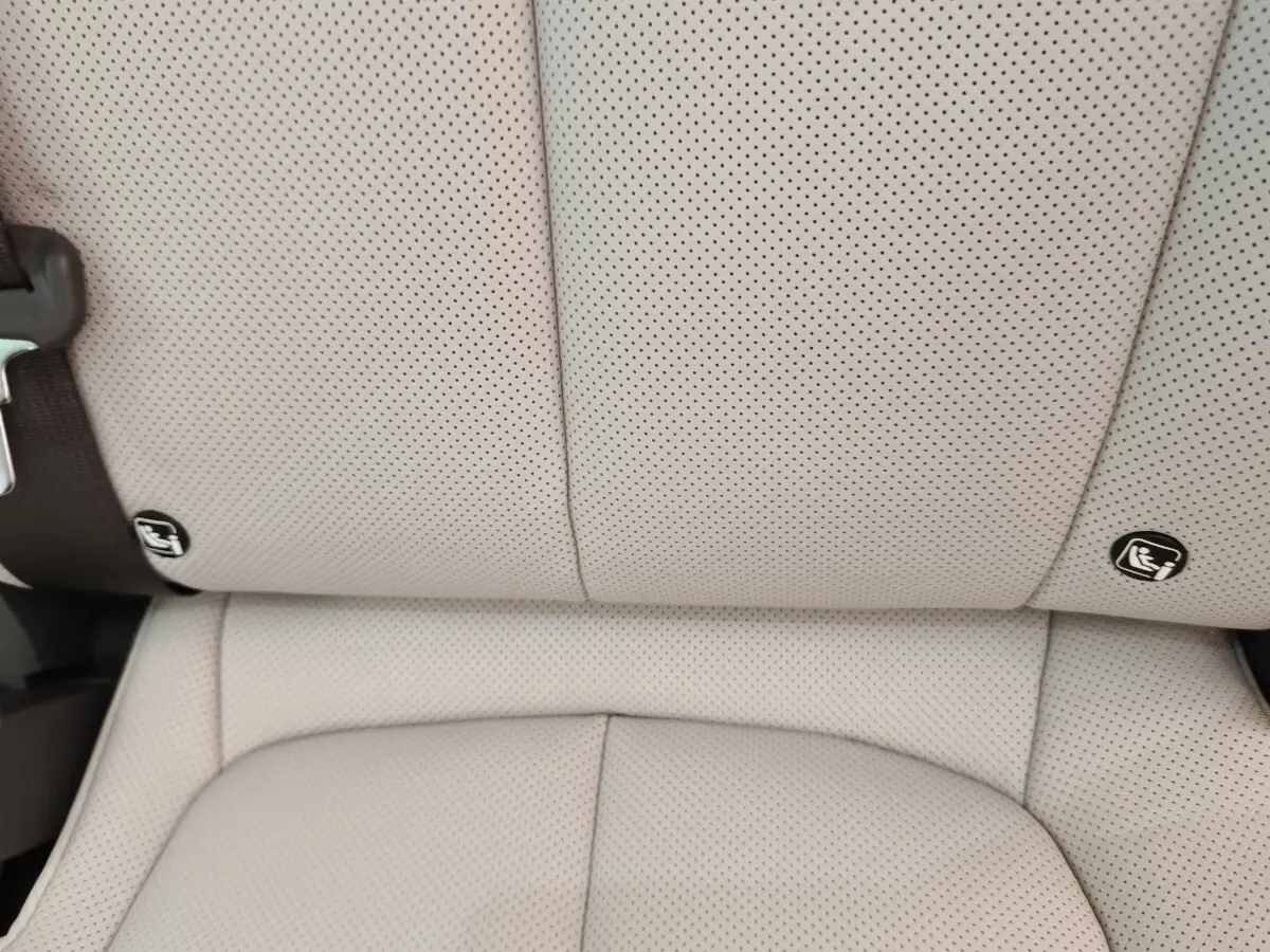 Gros plan sur la banquette arrière beige perforée du Hyundai IONIQ 2023 avec fixation ISOFIX visible.