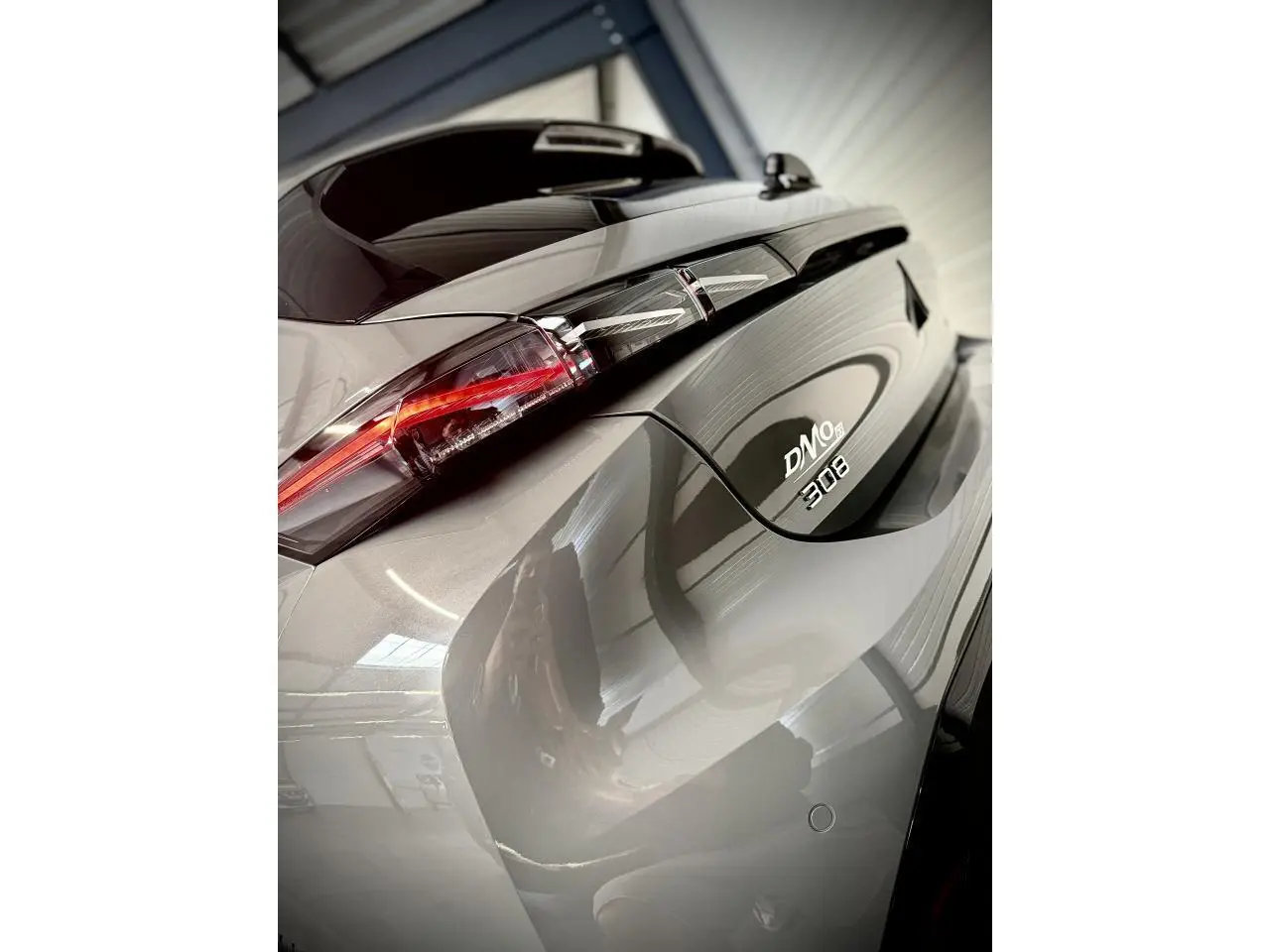 Gros plan sur l'arrière droit gris selenium de la Peugeot 308 avec feux LED et monogrammes distinctifs.