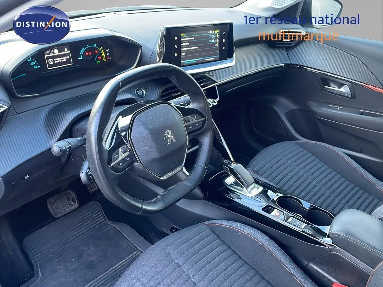 Intérieur de la Peugeot 208 électrique gris Artense vu côté conducteur, avec tableau de bord numérique et écran tactile central.