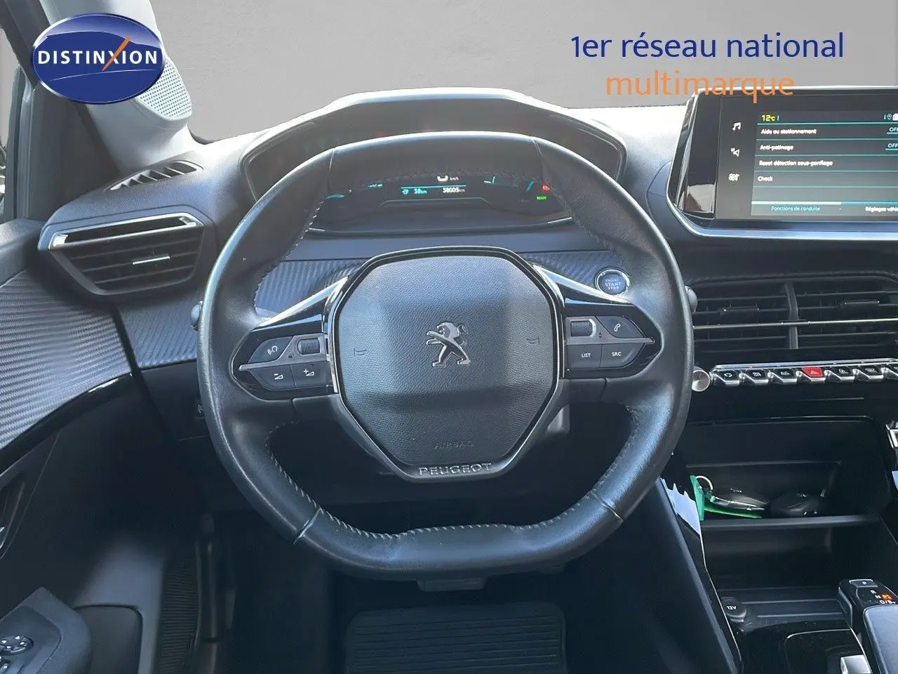 Vue centrée sur le volant cuir noir du Peugeot 208 électrique 2020 avec tableau de bord digital et écran tactile.