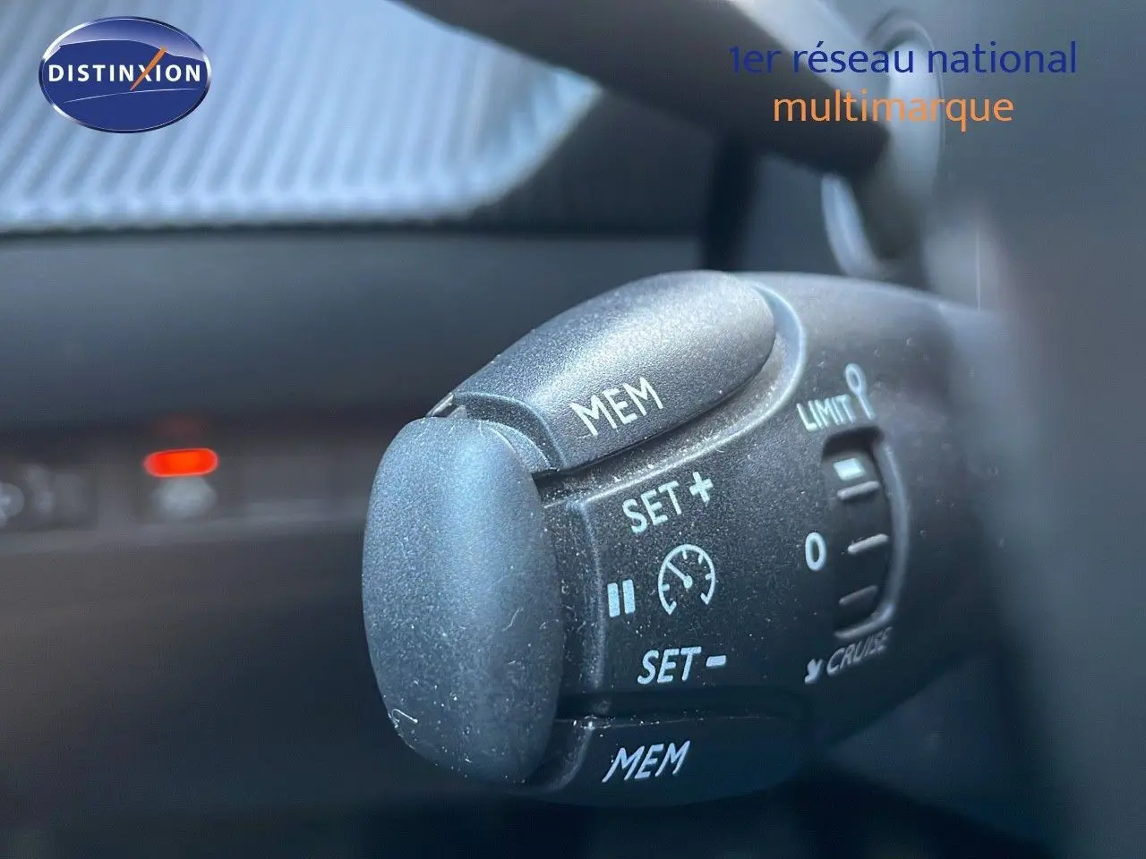 Gros plan sur la commande de régulateur de vitesse dans l'habitacle d'une Peugeot 208 électrique gris Artense.