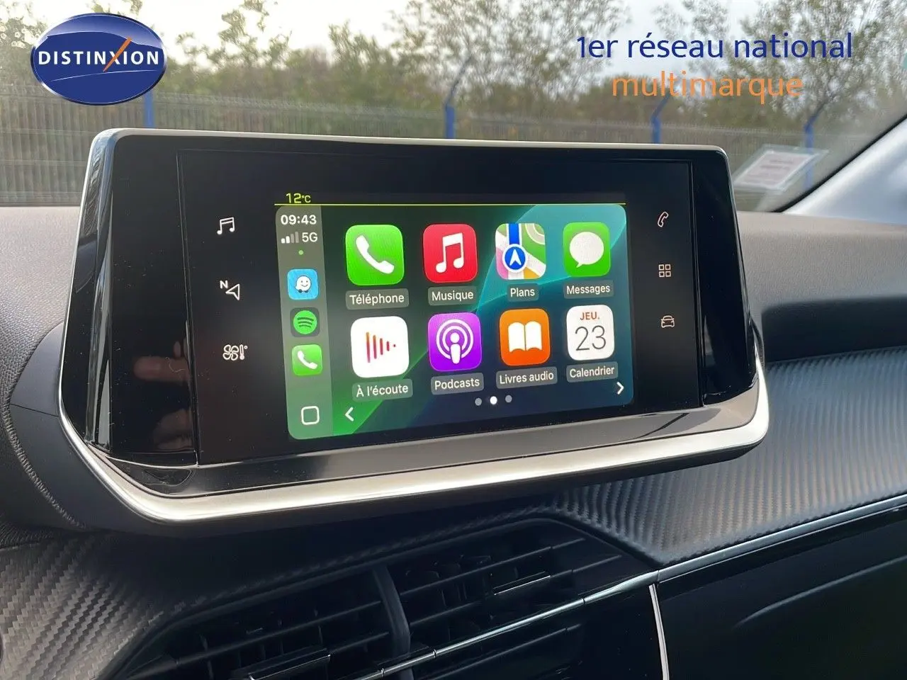 Écran tactile central affichant les applications connectées, intérieur moderne de la Peugeot 208 électrique gris Artense.