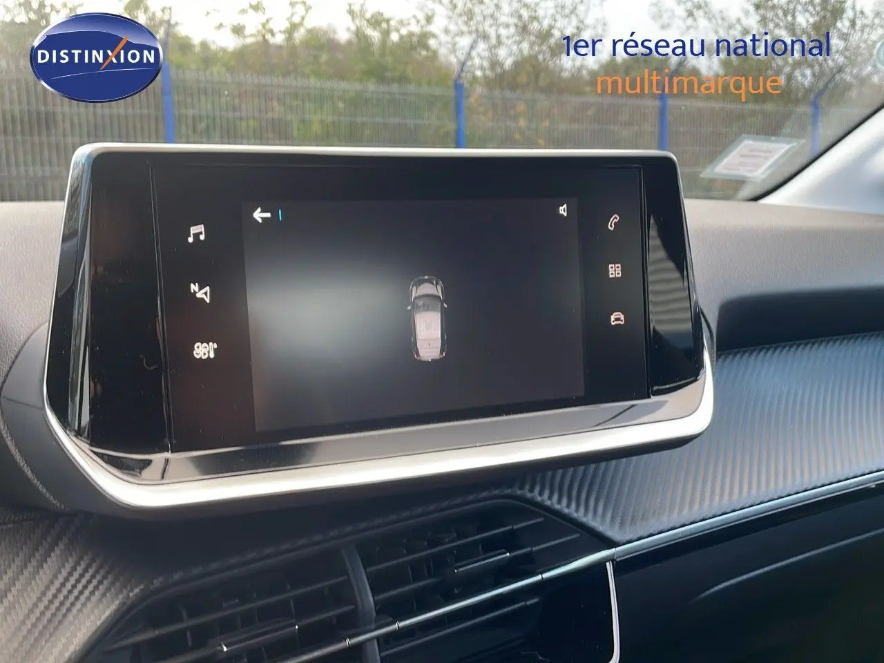 Écran tactile central affichant la vue 360° du véhicule dans l'habitacle d'une Peugeot 208 électrique gris Artense.