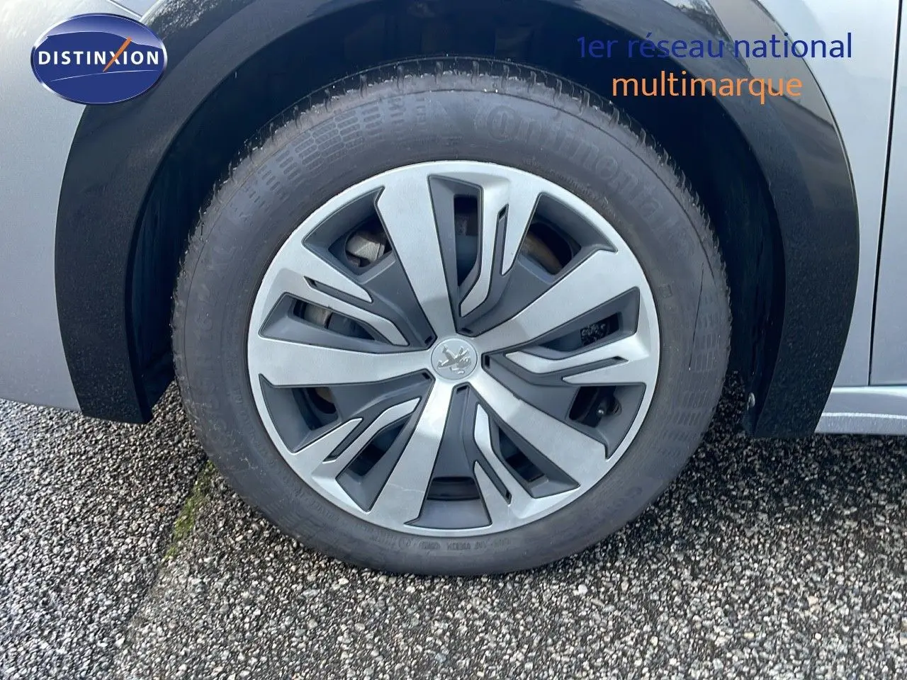 Gros plan sur la roue avant gauche de la Peugeot 208 électrique gris Artense, soulignant la jante au design moderne.