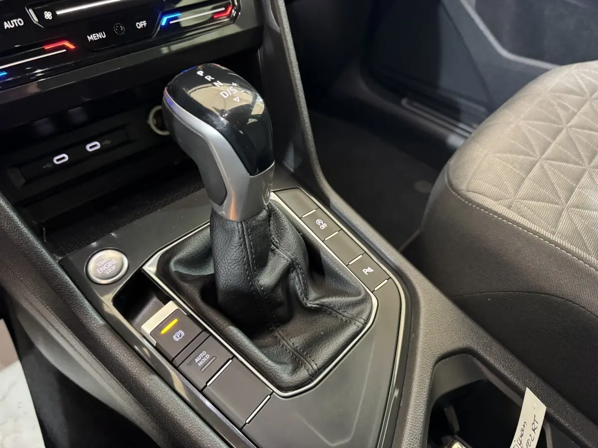 Gros plan sur la console centrale du Volkswagen Tiguan 2021 avec levier de vitesse automatique et bouton démarrage.