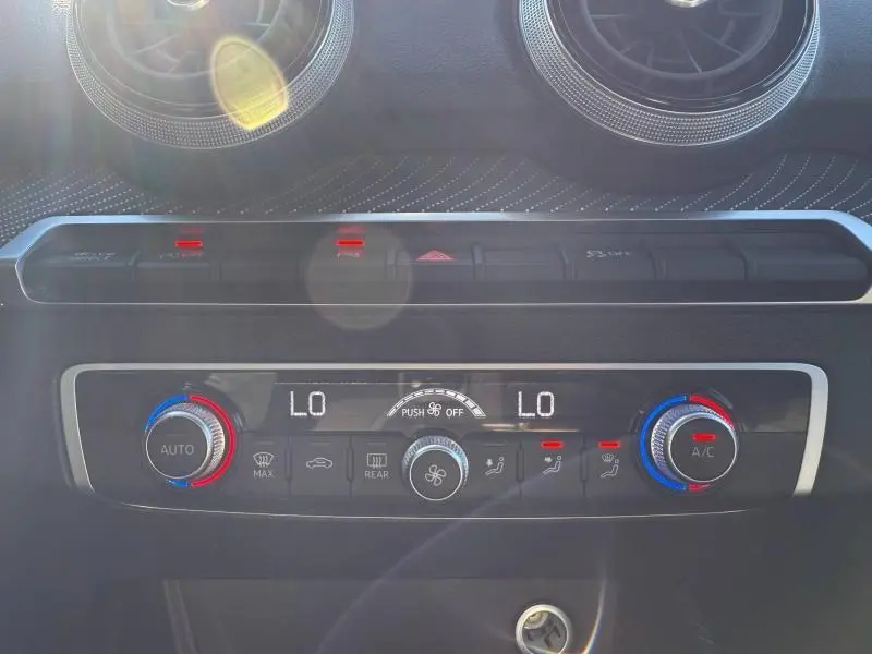 Tableau de bord de l'Audi Q2 35 TDI 150ch S line 2025, vue rapprochée sur la climatisation et aérateurs ronds.