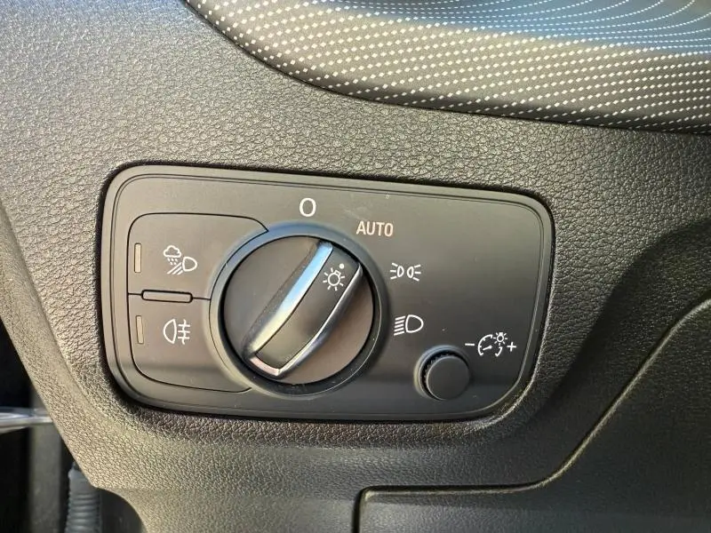 Gros plan sur le sélecteur de commandes d’éclairage intérieur de l’Audi Q2 35 TDI S line 2025, avec finition noire texturée.