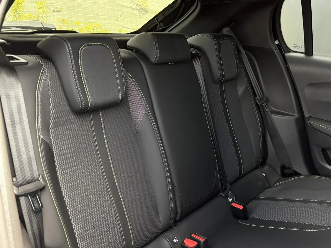 Vue intérieure sur la banquette arrière noire avec surpiqûres vertes de la Peugeot 208 Hybrid 110 e-DSC6 GT.
