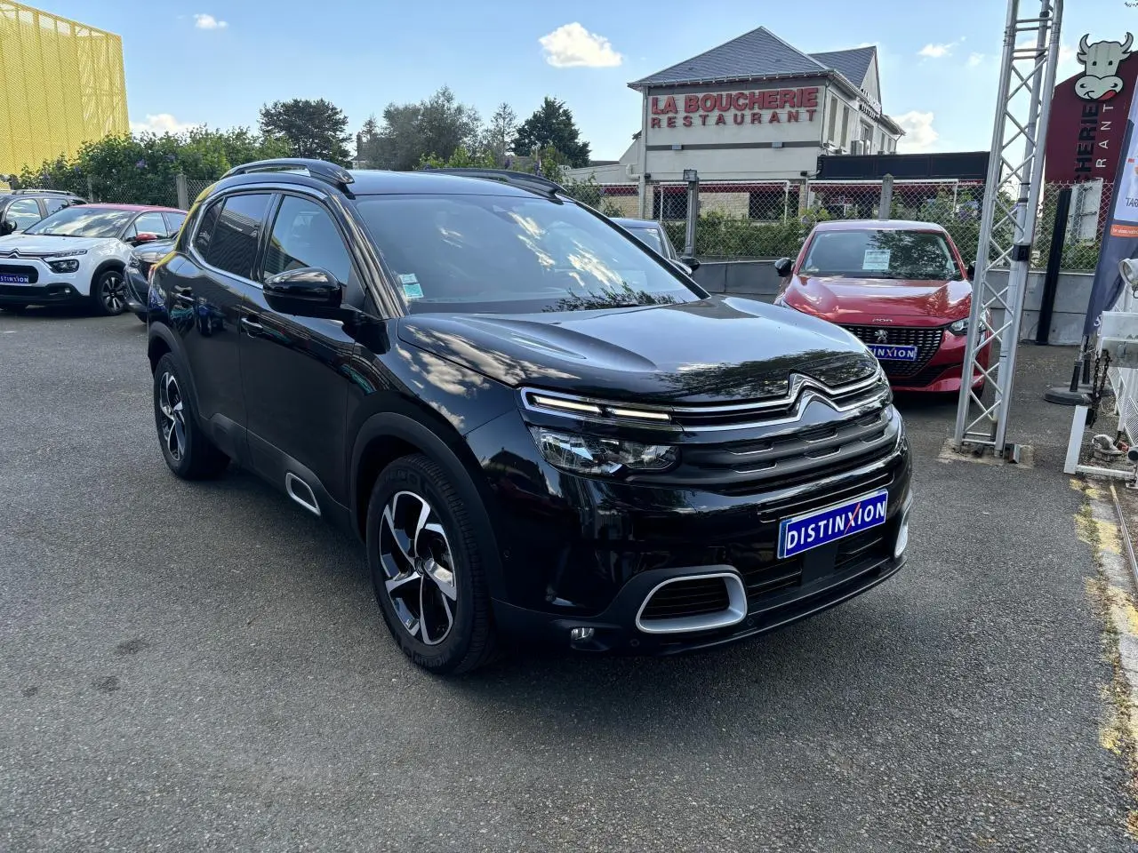 Citroën C5 Aircross noir métallisé en 3/4 avant droit, avec calandre distinctive et jantes bicolores visibles.