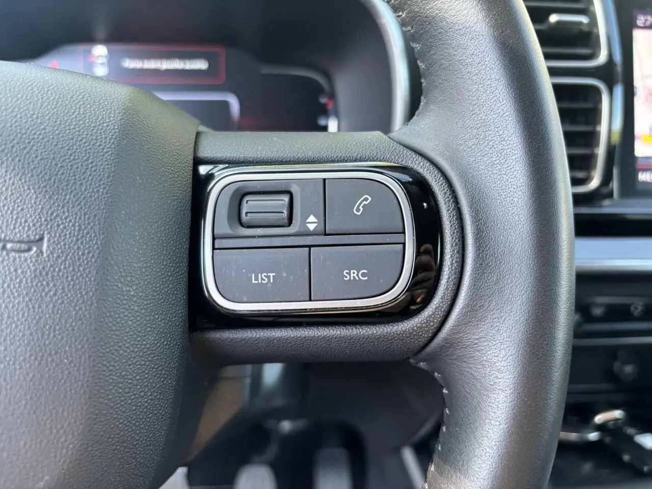 Gros plan sur les commandes au volant à droite du Citroën C5 Aircross 2019 noir métallisé, avec boutons de téléphone et audio.