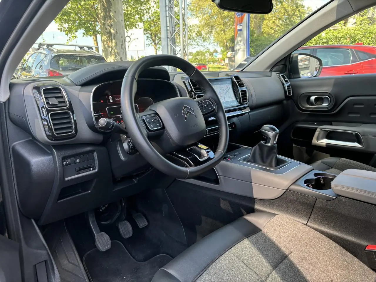 Intérieur du Citroën C5 Aircross 2019 vu côté conducteur, volant multifonction et levier de vitesses manuel visibles.