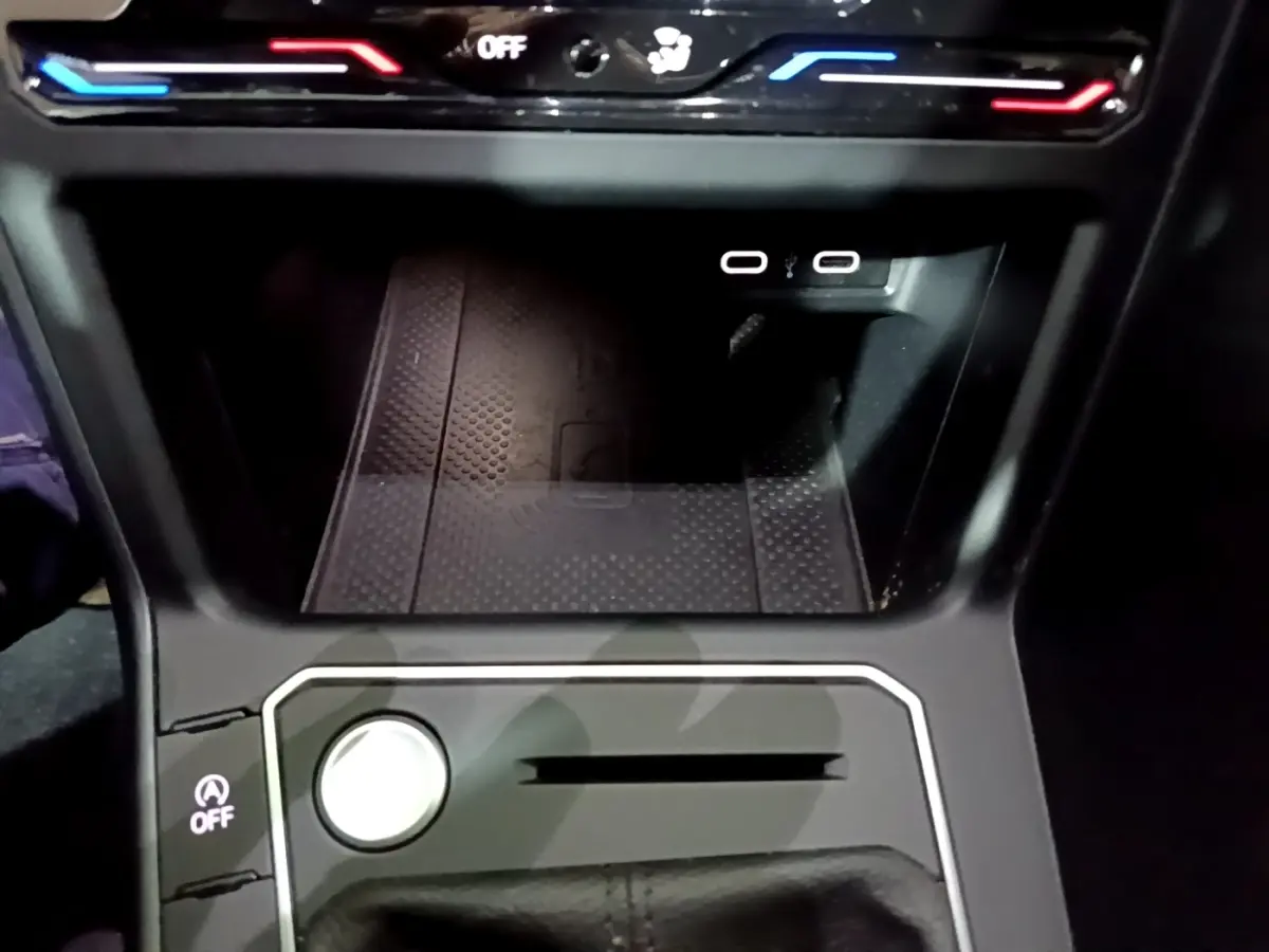 Gros plan sur la console centrale noire du Volkswagen Taigo 1.0 TSI 110 DSG R-Line avec boutons et ports USB visibles.