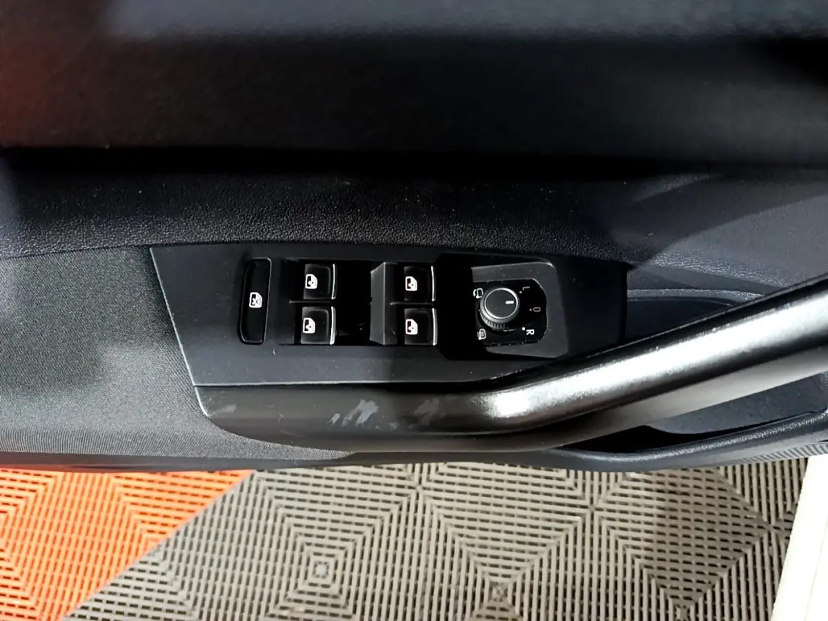 Gros plan sur la commande des vitres et rétroviseurs côté conducteur du Volkswagen Taigo blanc, version R-Line 2022.