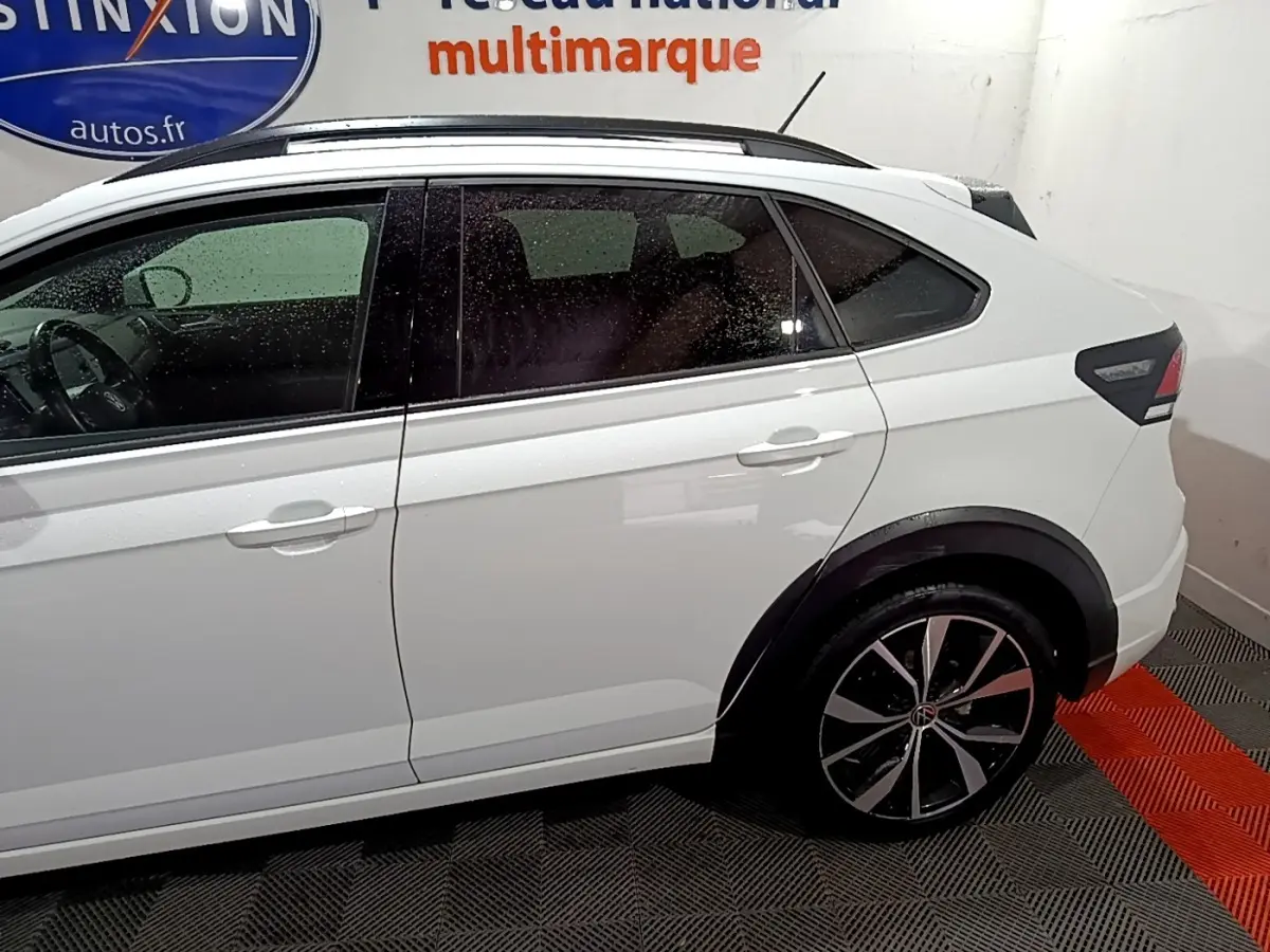 Vue latérale droite d'un Volkswagen Taigo blanc 2022 avec jantes alliage et rails de toit noirs.