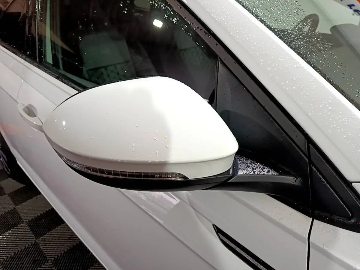 Rétroviseur côté gauche blanc de Volkswagen Taigo 1.0 TSI 110 DSG R-Line 2022 avec carrosserie blanche humide.