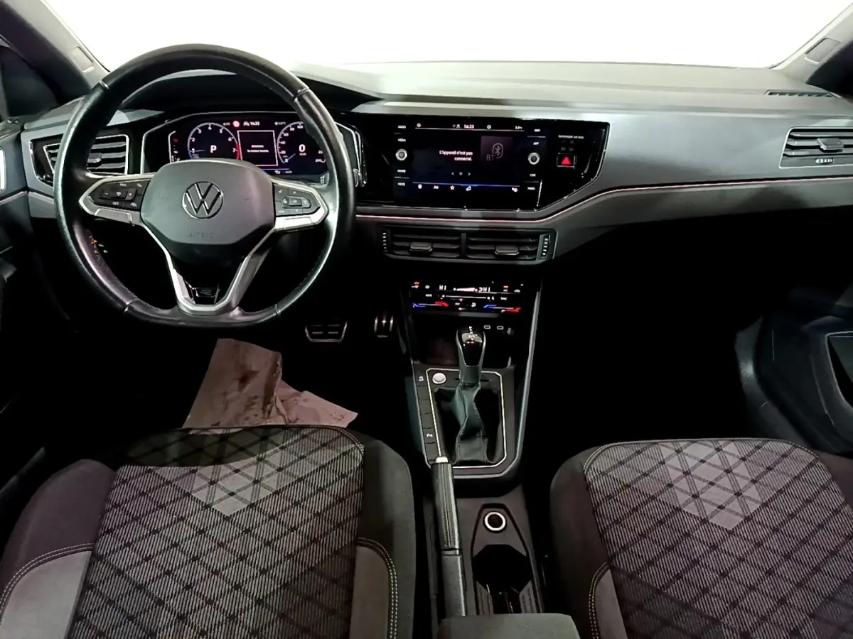 Vue intérieure frontale du Volkswagen Taigo 1.0 TSI 110 DSG R-Line avec volant cuir alu multifonctions et tableau de bord digital.