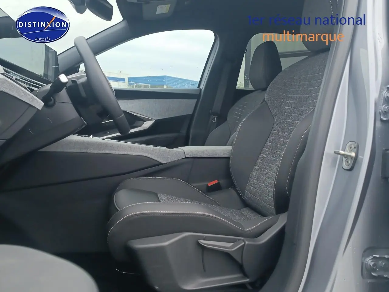 Vue intérieure côté conducteur du Peugeot 5008 gris artense, mettant en valeur le siège avant en tissu et cuir avec coutures contrastées.