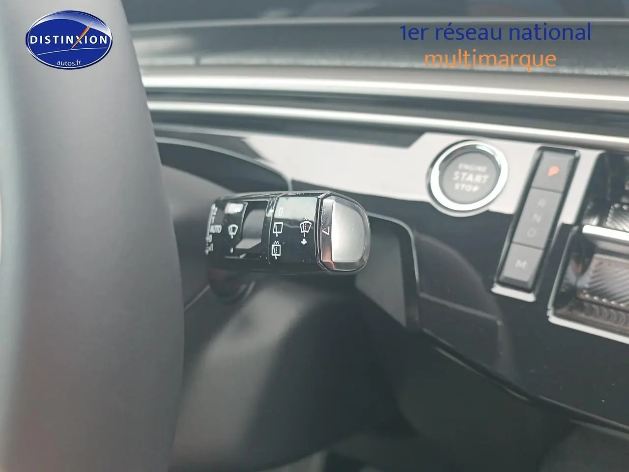 Détail de la commande d’essuie-glace sur le volant d’un Peugeot 5008 gris Artense, intérieur moderne et épuré.