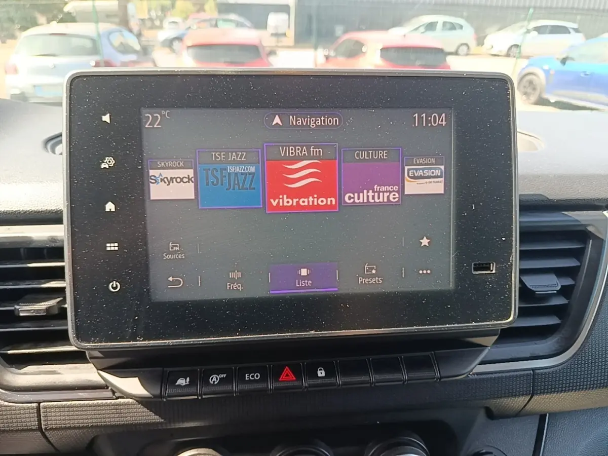 Écran tactile central du Renault Trafic Fourgon blanc 2023 affichant les stations radio, vue intérieure avant.