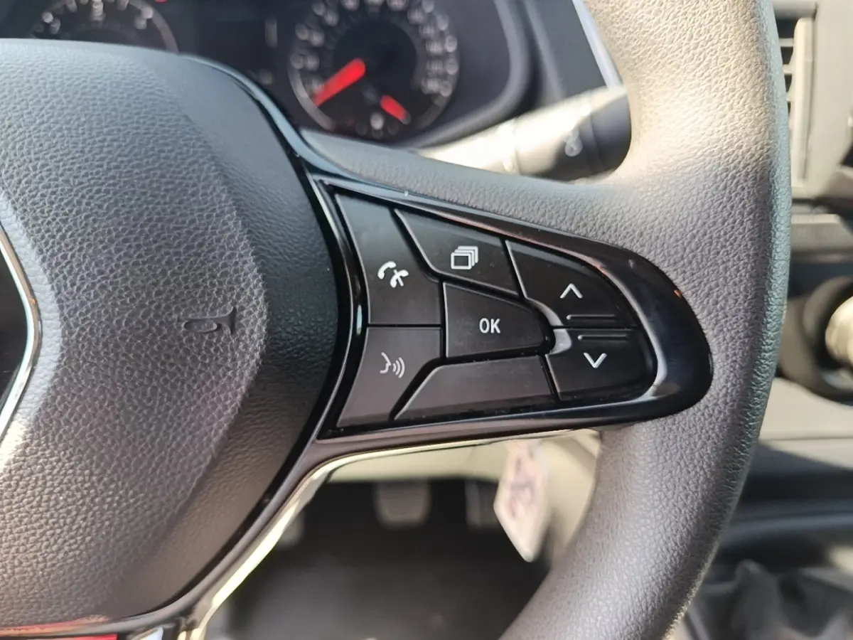 Gros plan sur le volant multifonctions noir du Renault Trafic Fourgon 2023, montrant les commandes de navigation et téléphone.