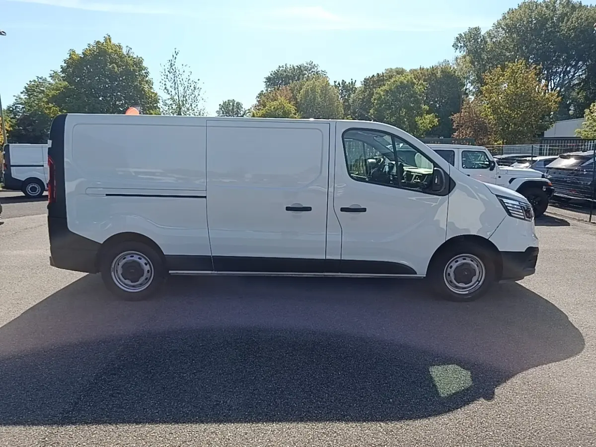 Renault Trafic Fourgon blanc vu de profil côté droit, avec portes latérales et jantes acier noires.