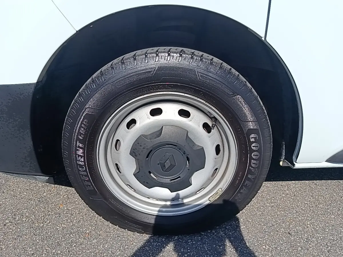 Gros plan sur la roue avant droite d’un Renault Trafic blanc avec jante acier et logo Renault central.
