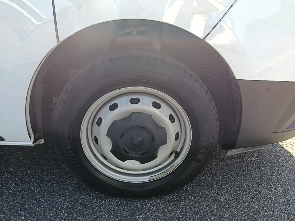 Gros plan sur la roue avant droite en jante acier du Renault Trafic Fourgon blanc, avec logo Renault au centre.