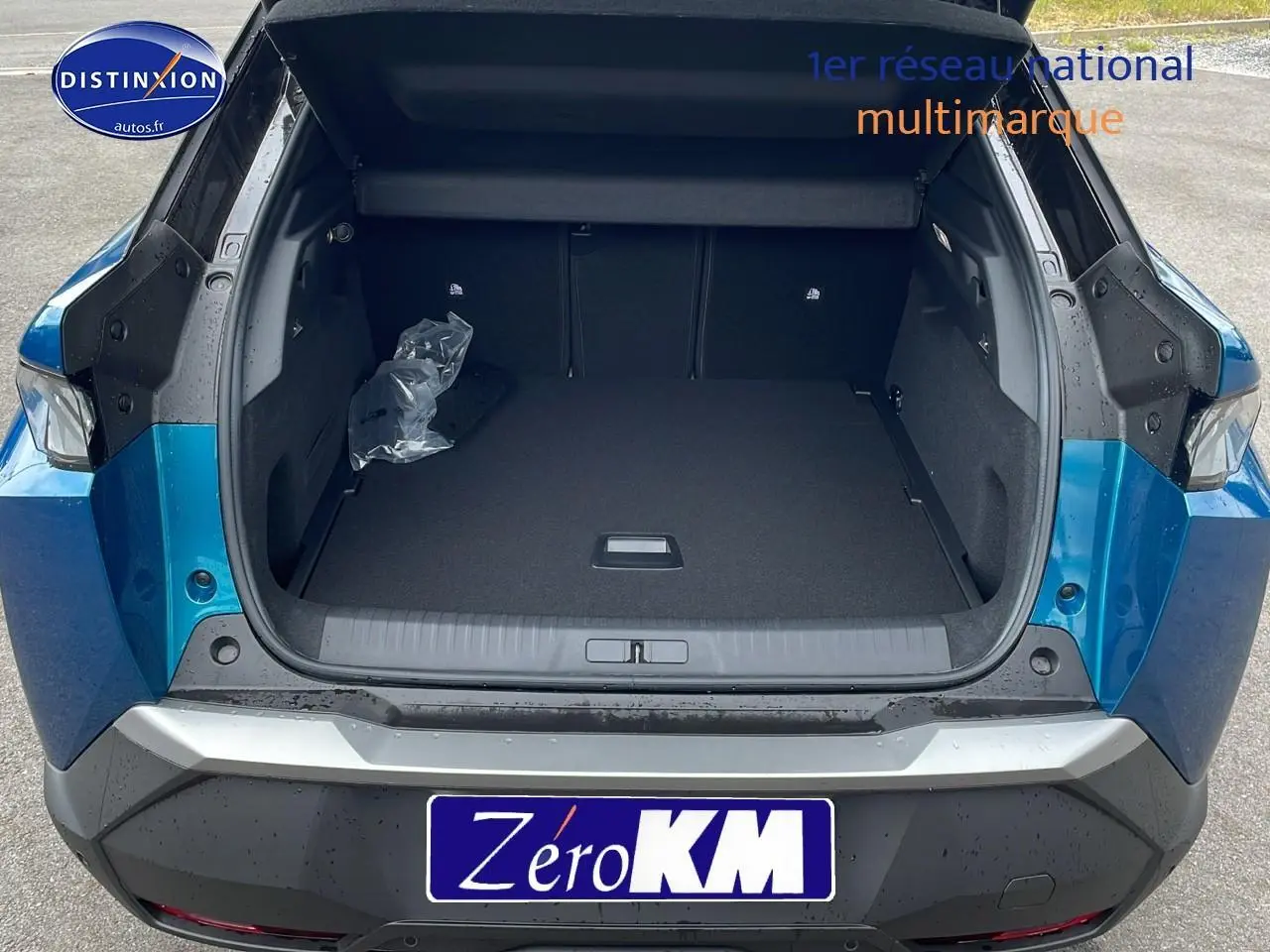 Coffre ouvert en vue arrière d'un Peugeot 3008 Hybrid 145 GT e-dcs6 bleu obsession avec hayon motorisé.