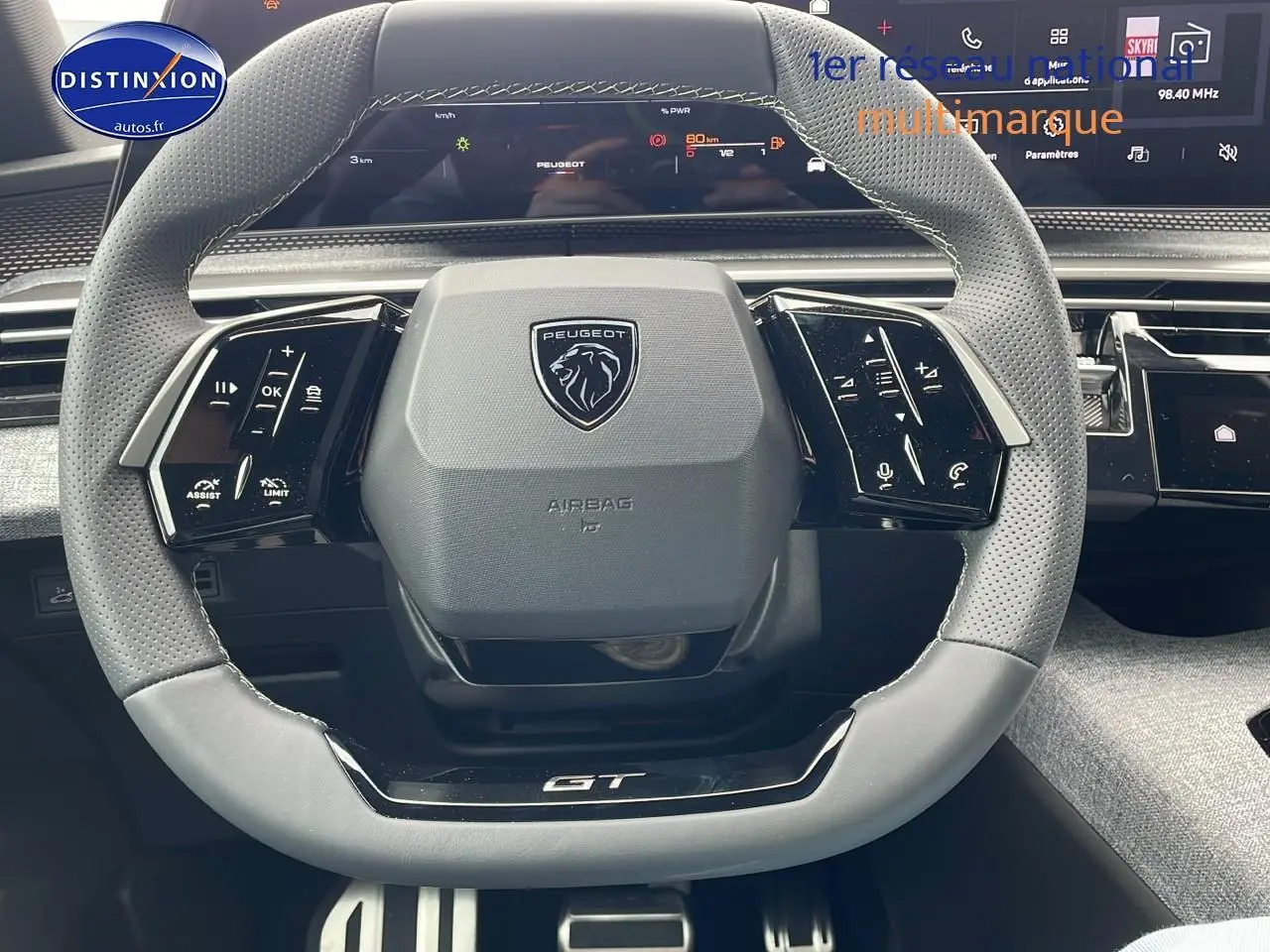 Volant cuir perforé avec logo Peugeot et inscription GT, tableau de bord numérique du 3008 Hybrid 145 gt e-dcs6.