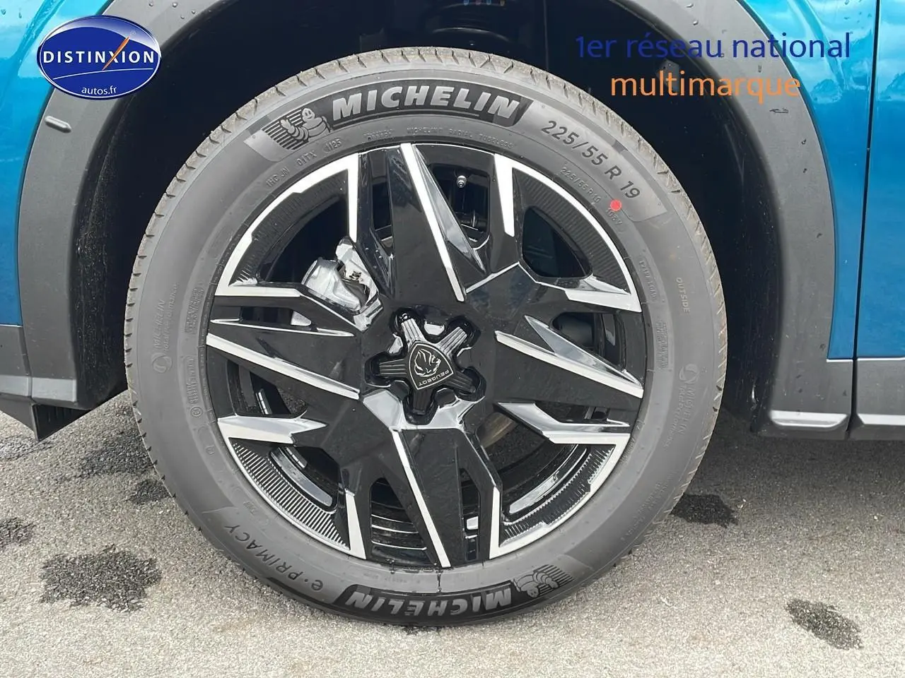 Gros plan sur la roue avant gauche du Peugeot 3008 Hybrid 145 GT e-dcs6 bleu obsession avec jante alu noire et argent.