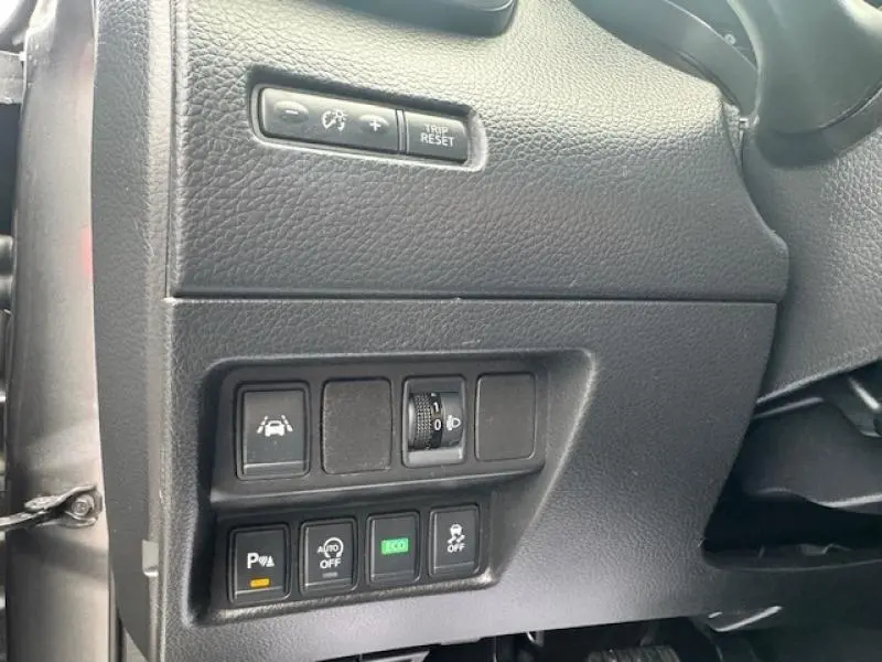 Vue rapprochée des commandes de sécurité et d'éclairage côté gauche du tableau de bord du Nissan Qashqai gris Squale 2015.