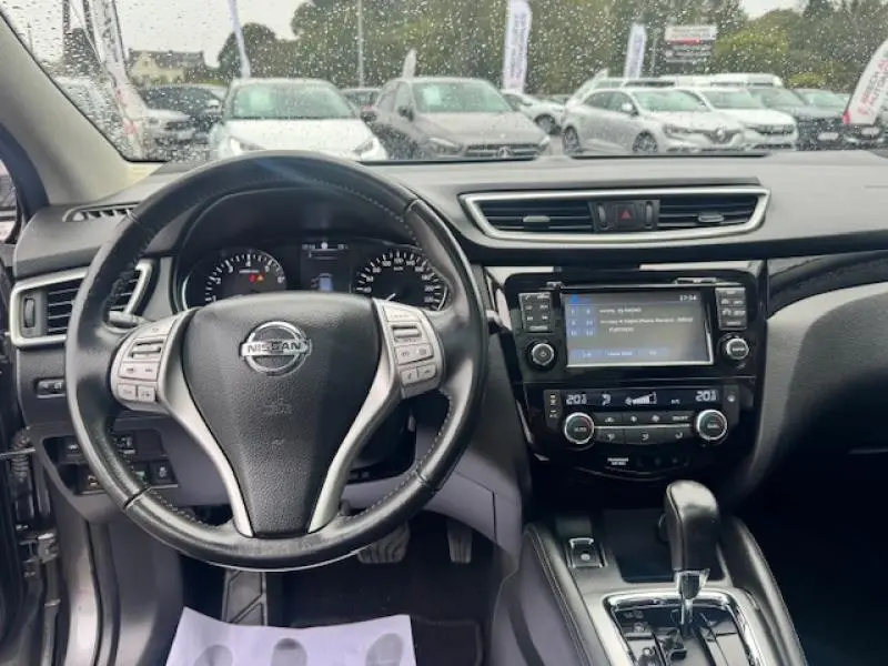 Vue intérieure du tableau de bord et volant cuir multifonction du Nissan Qashqai gris Squale, avec écran tactile et boîte auto.