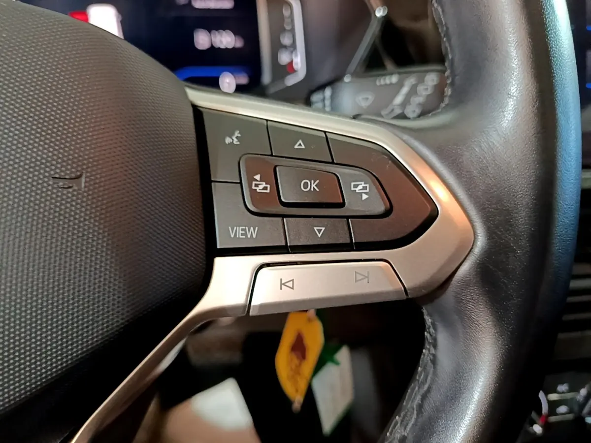 Gros plan sur le côté gauche du volant cuir multifonctions du Volkswagen T-Cross gris foncé 2023.