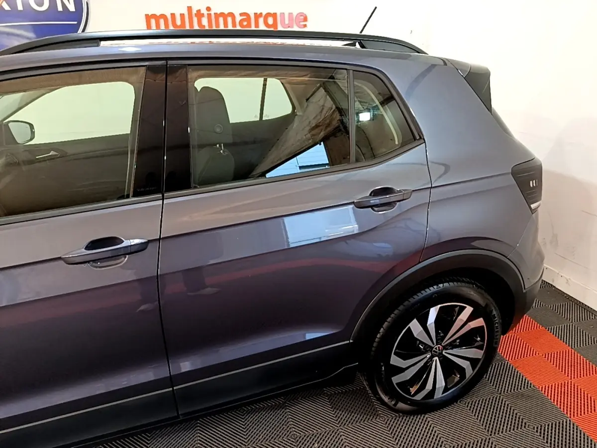 Vue latérale droite du Volkswagen T-Cross gris foncé 2023, mettant en valeur la porte arrière et la roue arrière au design moderne.