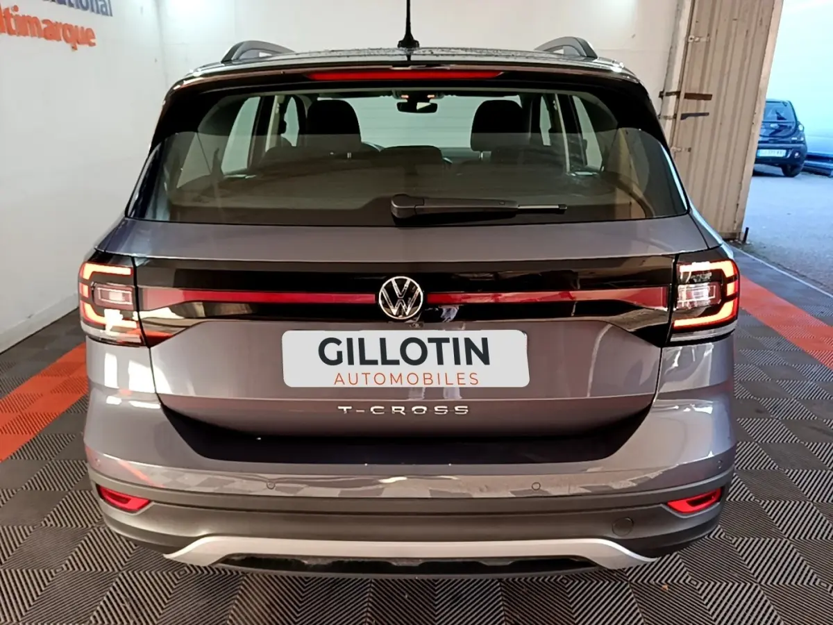 Vue arrière d’un Volkswagen T-Cross gris foncé 2023 avec feux LED et logo VW bien visibles.